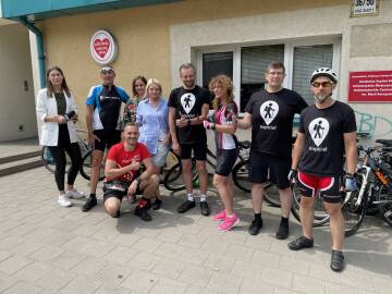 Grupa rowerzystów przed budynkiem